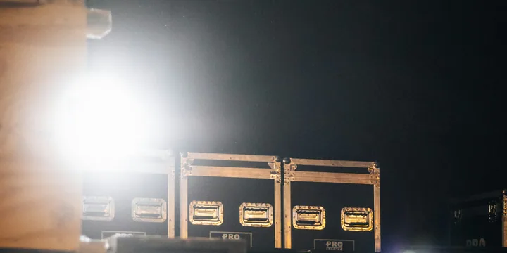 Stacked road cases caught in a single hard light backstage.